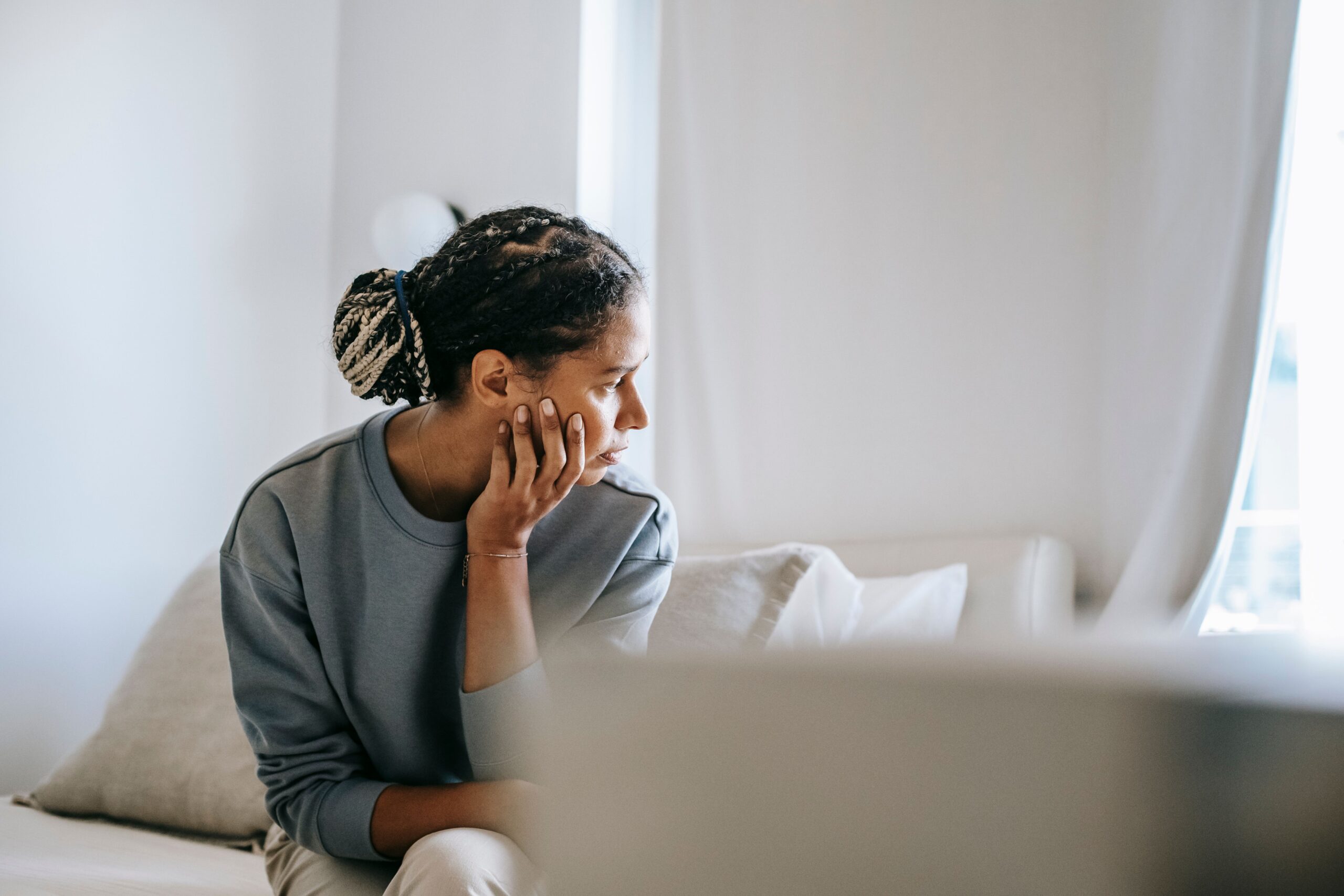 Young woman struggling to focus at a laptop, ADHD assessment and treatment
