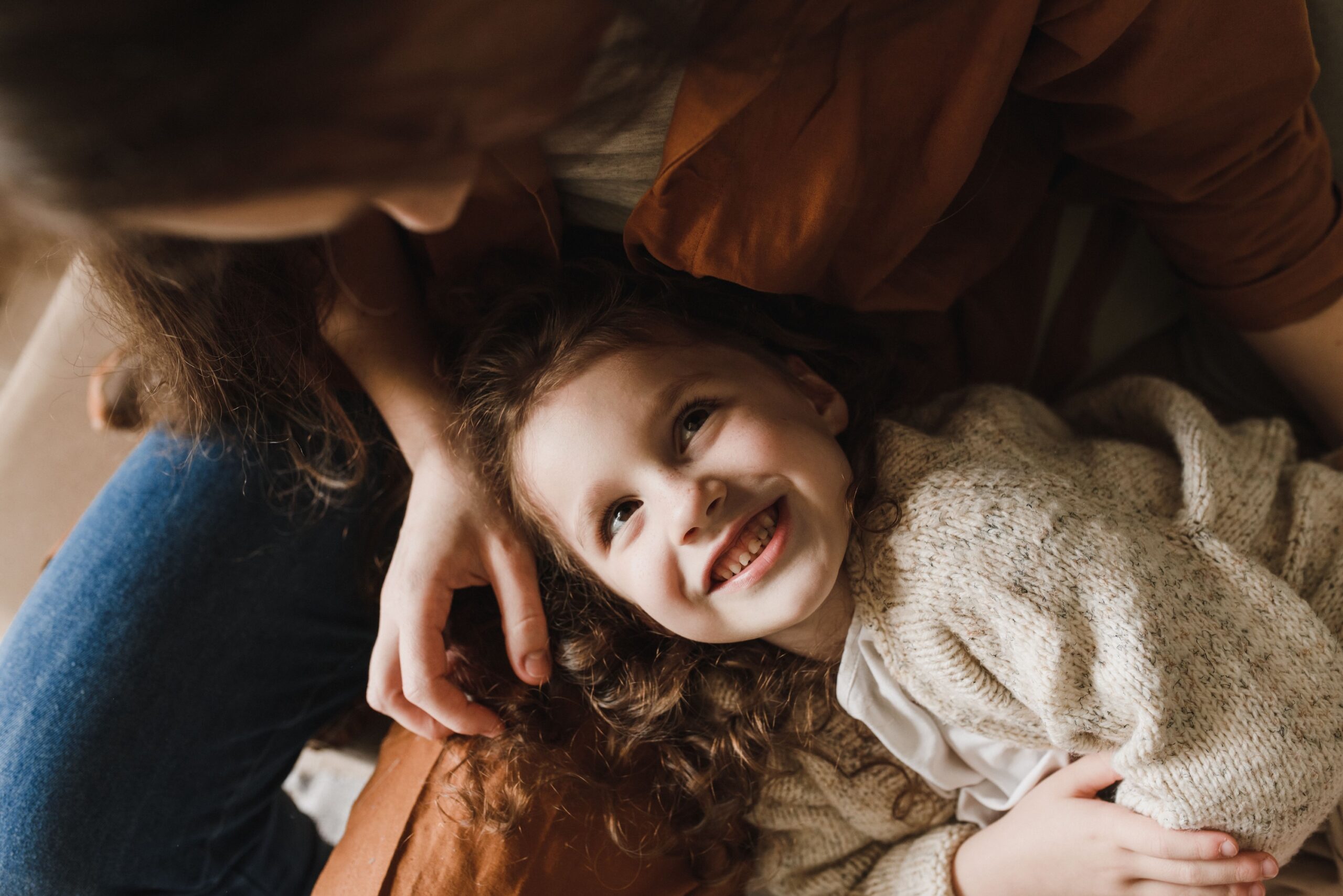 Parent and child lying close together and smiling
