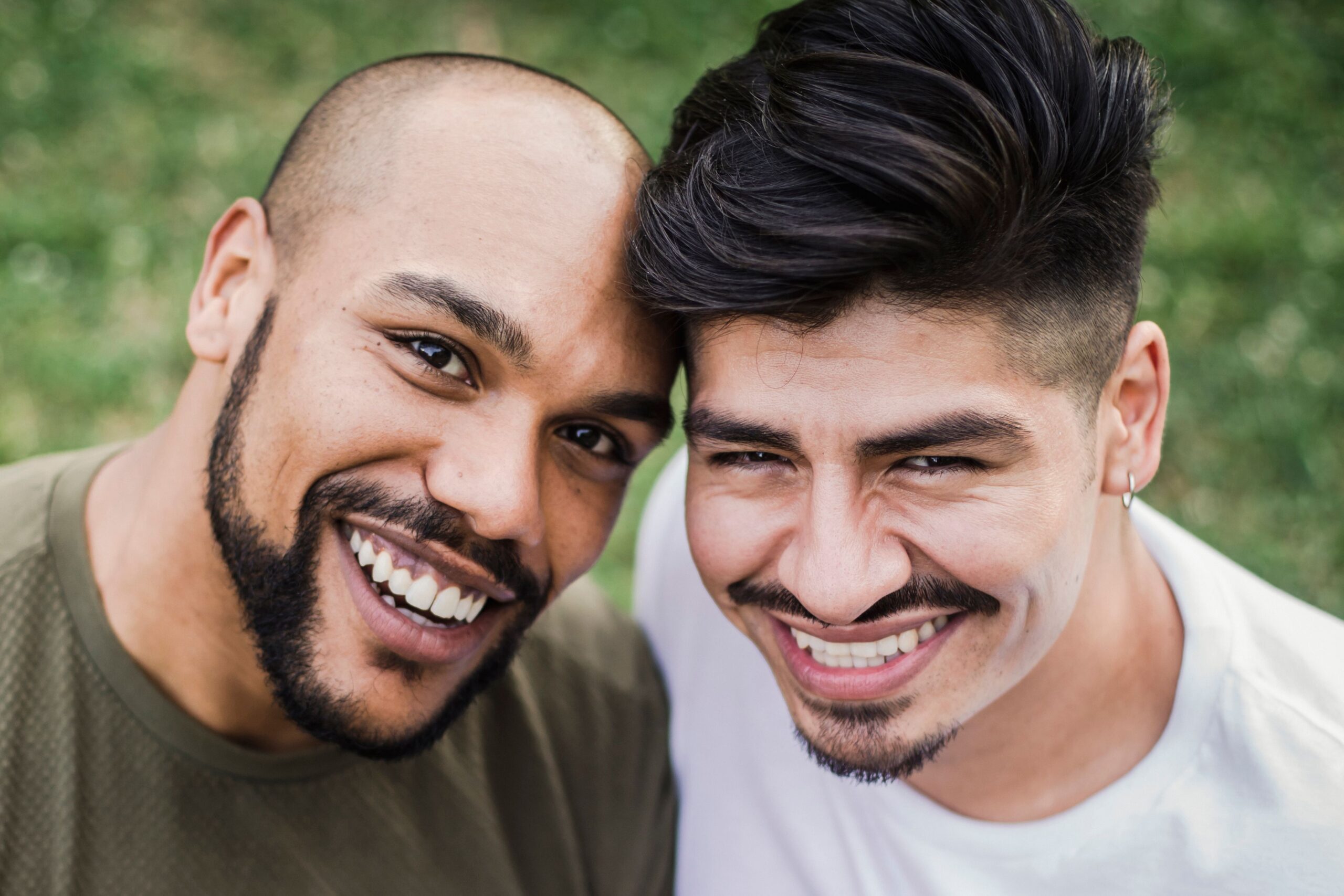 Two men smiling together outdoors, couples therapy at Unfold Psychology