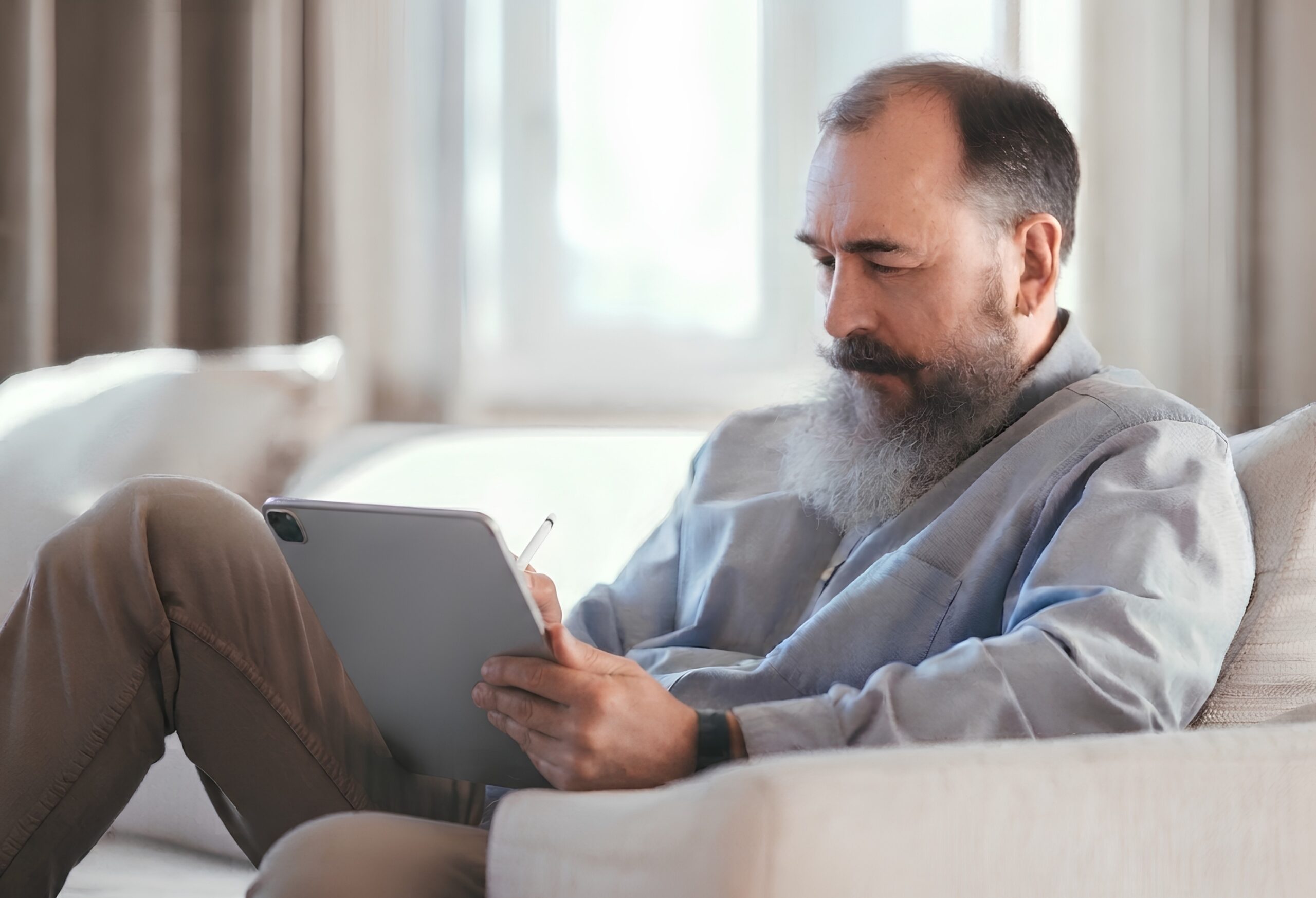 Adult using a tablet on a couch, COGMED working memory training