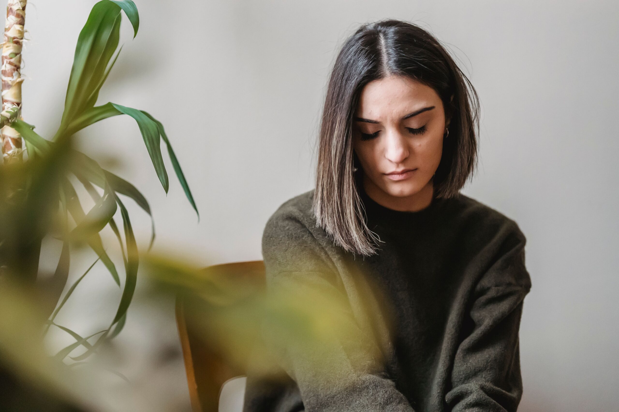 Woman looking down in quiet reflection, grief counseling